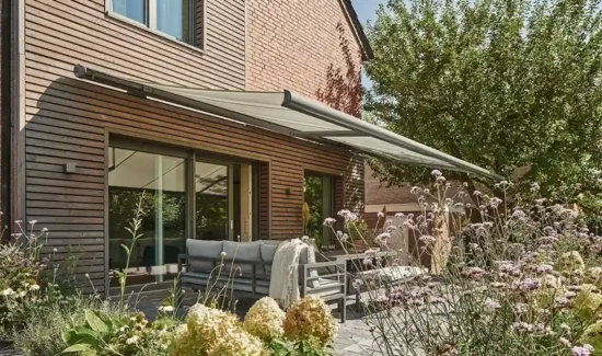 Moderne Terrasse mit Sonnenmarkise und üppiger Bepflanzung