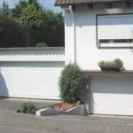Weißes Garagentor Kassel neben Haus